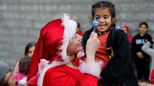 Иракчанка облечена като Дядо Коледа раздаде подаръци на разселени деца