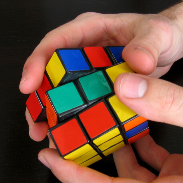 Студент подрежда три кубчета на Рубик, докато жонглира с тях