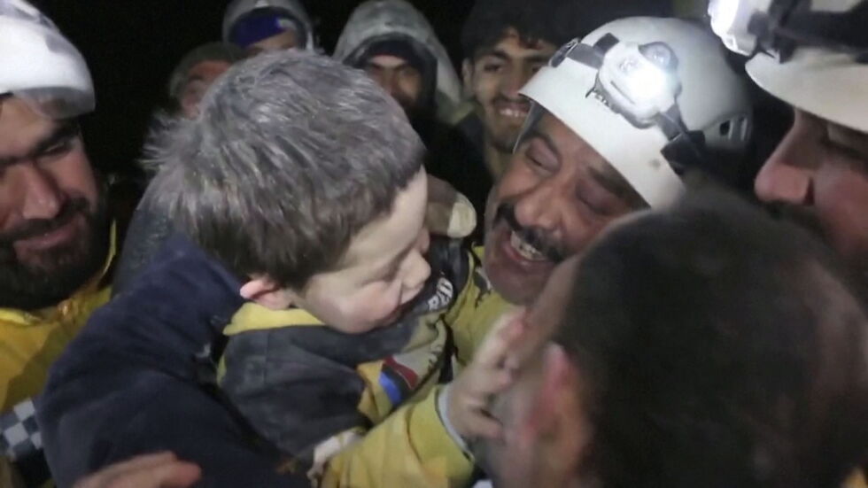 Сирийско момче си играе със спасителите, след като го извадиха от развалините
