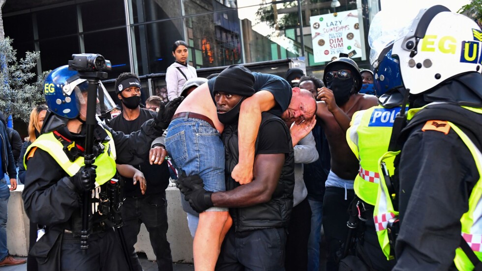 Достойна постъпка: Тъмнокож протестиращ носи на гърба си ранен контрапротестиращ